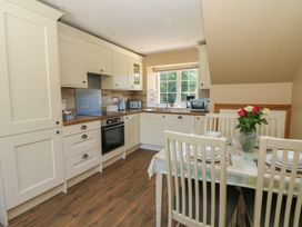 A kitchen with cabinets and a dining area at Felin Gogoyan Tregaron