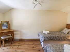 A bedroom with two beds and a mirror at Felin Gogoyan in Tregaron