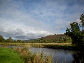 A river surrounded by grass and trees at Felin Gogoyan Tregaron