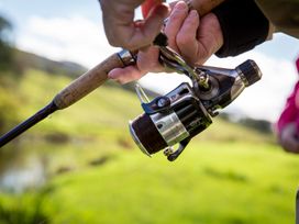 A close-up of a fishing rod and reel outdoors in a natural setting
