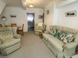 A living room with a sofa and armchair at 23 Beach Road Y Felinheli