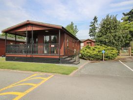 A lodge with a balcony and surrounding greenery at Snowdrop in Eardisland