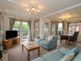 A living room with a sofa and dining table at Snowdrop in Eardisland