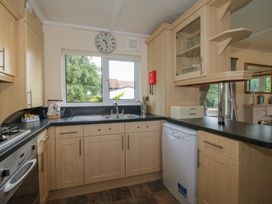 A kitchen with a sink and dishwasher at Snowdrop in Eardisland