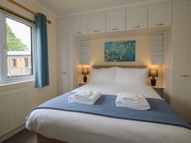 A bedroom with a bed and lamp at Snowdrop in Eardisland