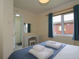 A bedroom with a bed and a desk at Snowdrop in Eardisland