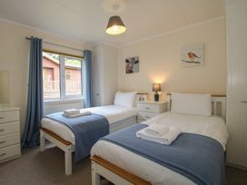 A bedroom with two beds and a window at Snowdrop in Eardisland