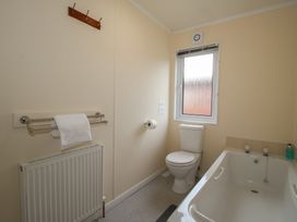A bathroom with a bathtub and toilet at Snowdrop in Eardisland