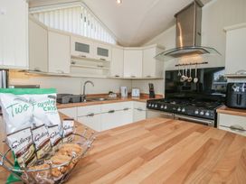 A kitchen with a wooden island and kitchen appliances at Daisy in Eardisland