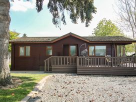 A house with a deck and swing in front at Foxglove Eardisland