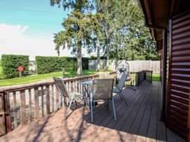 An outdoor deck with table and chairs at Foxglove in Eardisland