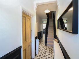 A hallway with a staircase and a door at Sunrise House Pakefield near Lowestoft