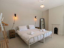 A bedroom with a bed and a mirror at Sunrise House in Pakefield near Lowestoft