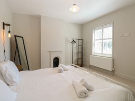 A bedroom with a bed and a mirror at Sunrise House in Pakefield near Lowestoft