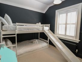 A bedroom with a bunk bed and a slide at Sunrise House in Pakefield near Lowestoft