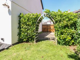 A garden with an archway and greenery at Sunrise House Pakefield near Lowestoft