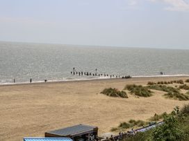A beach with groynes and people at Sunrise House in Pakefield near Lowestoft