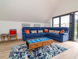 A living room with a blue sofa and coffee table at Pebble Ridge View in Westward Ho!