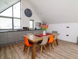 A kitchen with a dining area and flowers on the table at Pebble Ridge View in Westward Ho!