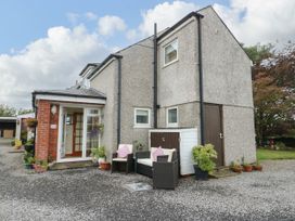 An outdoor area with a house and seating at The Cottage at Ty Newydd Brynsiencyn