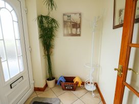 A hallway with a plant and coat rack at The Cottage at Ty Newydd in Brynsiencyn