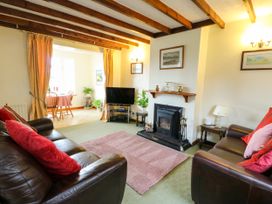 A living room with a fireplace and television at The Cottage at Ty Newydd in Brynsiencyn