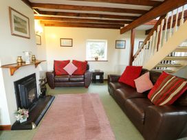 A living room with a fireplace and two sofas at The Cottage at Ty Newydd in Brynsiencyn