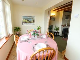 A dining room with a table set for meals at The Cottage at Ty Newydd in Brynsiencyn