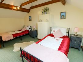 A bedroom with two beds and nightstands at The Cottage at Ty Newydd in Brynsiencyn