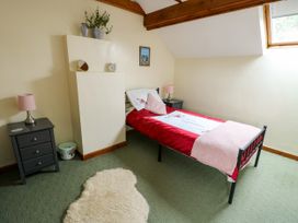 A bedroom with a bed and bedside tables at The Cottage at Ty Newydd Brynsiencyn
