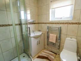 A bathroom with a shower, sink, toilet, and towel radiator at The Cottage at Ty Newydd Brynsiencyn