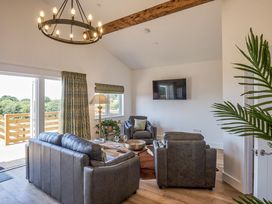 A living room with a sofa and television at Heritage Retreat in Monknash