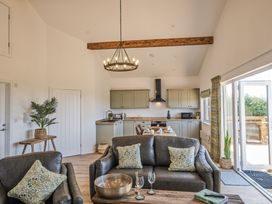 A living room with a kitchen area at Heritage Retreat Monknash