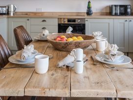 A kitchen with a wooden table and fruit bowl at Heritage Retreat in Monknash