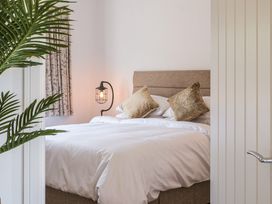 A bedroom with a bed and lamp at Heritage Retreat in Monknash