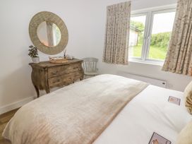 A bedroom with a bed and a wooden table at Heritage Retreat Monknash