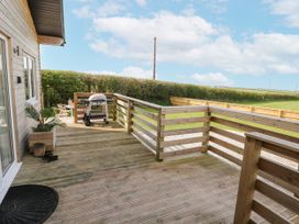 A decking area with a barbecue at Heritage Retreat Monknash