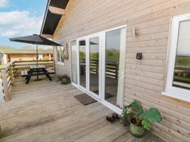 An outdoor area with a table and umbrella at Monks Rest in Monknash