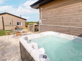 An outdoor area with a hot tub and seating at Monks Rest in Monknash