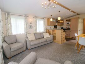A living room with a sofa and dining area at Dove in Shobdon