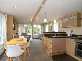 A living room with a kitchen area and dining table at Dove in Shobdon
