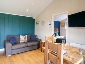 A living room with a sofa and dining table at Hazel Oakthorpe near Donisthorpe