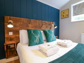 A bedroom with a bed and wooden headboard at Hazel in Oakthorpe near Donisthorpe