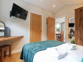 A bedroom with a television and a mirror at Hazel in Oakthorpe near Donisthorpe
