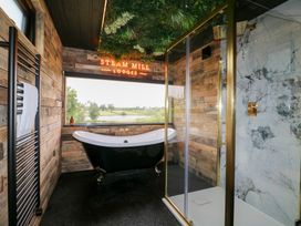 A bathroom with a bathtub and shower at Steam Mill Lodges in Oakthorpe near Donisthorpe