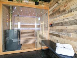 A sauna with a glass door and wooden bench at Hazel in Oakthorpe near Donisthorpe