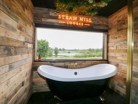 A bathroom featuring a bathtub and a view at Steam Mill Lodges in Oakthorpe near Donisthorpe