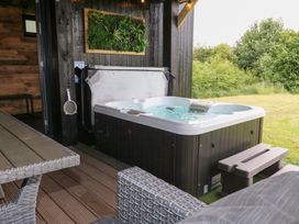 A hot tub next to outdoor seating and table at Hazel in Oakthorpe near Donisthorpe