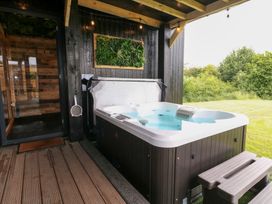 A hot tub on a wooden deck in an outdoor area at Hazel in Oakthorpe near Donisthorpe