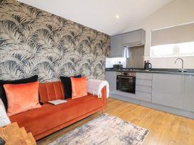 A living room with a sofa and kitchen unit at Birch in Oakthorpe near Donisthorpe